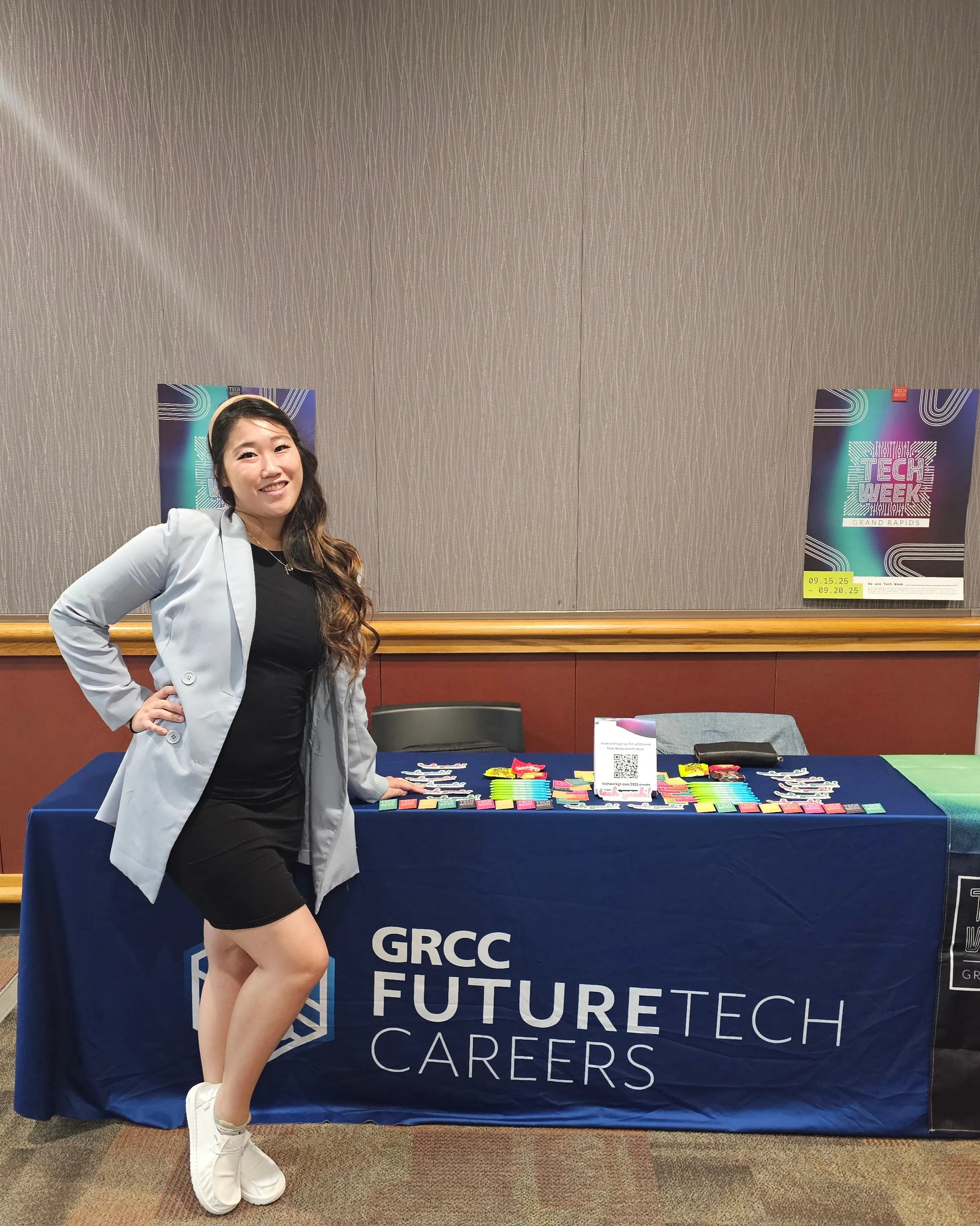 Standing at the GRCC FutureTech Careers table beside a Tech Week Grand Rapids poster