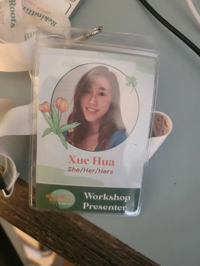 A "Workshop Presenter" lanyard badge for Xue Hua with tulips and a clover illustrated on it